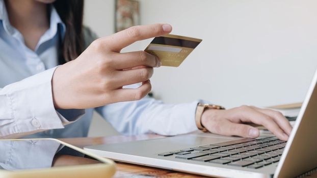 Online payment,woman's hands holding credit card using laptop for online shopping. 
