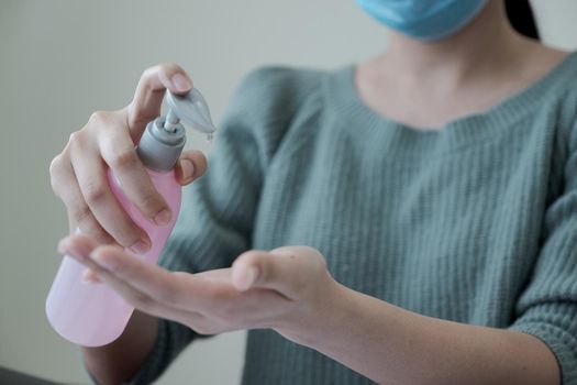 Asian people using alcohol antiseptic gel and wearing prevention mask,prevent against infection of Covid-19 outbreak,woman washing hands with hand sanitizer to avoid contaminating with Corona virus
