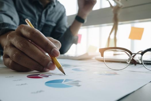 Photo of hands holding pencil and pressing laptop computer for calculating financial marketing
