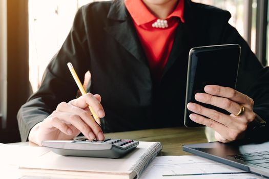  business woman looking at smart phone user calculator unexpected financial bills charges isolated in office.