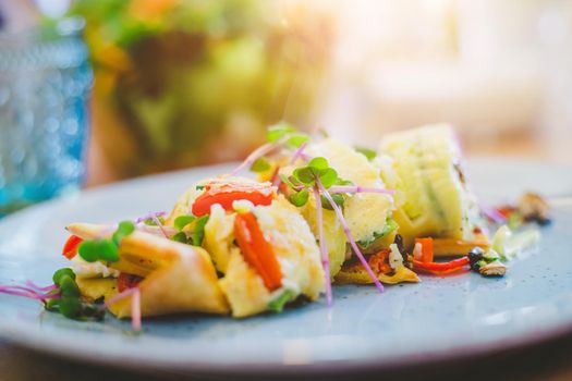 Close up of egg omelet with fresh vegetables. Placed on white ceramic plate.