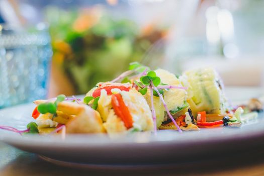 Close up of egg omelet with fresh vegetables. Placed on white ceramic plate.