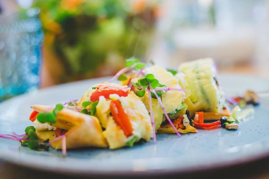 Close up of egg omelet with fresh vegetables. Placed on white ceramic plate.