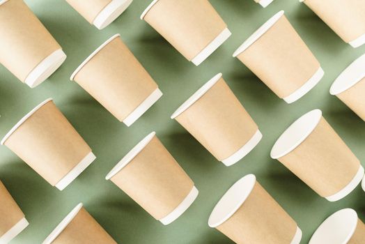 Reusable, disposable and recycling concept. Disposable paper cups pattern top view on green background