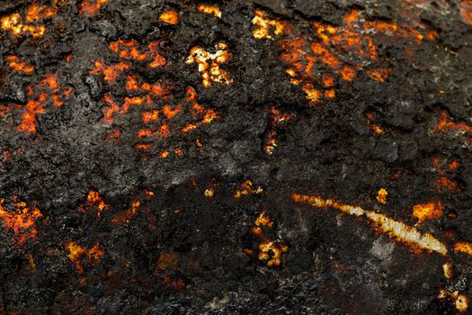 Bottom side of a cast iron pan with thicl layer of soot on its surface. Texture and background.