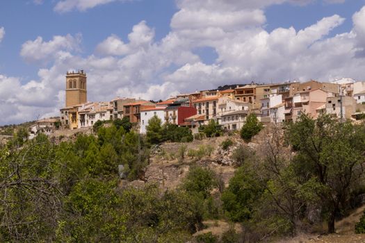 Wide-shot of an old town on a hill with a clock tower on a sunny day