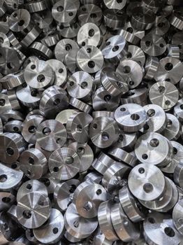 full frame view on heap of round steel cylindrical parts after eccentric drilling.