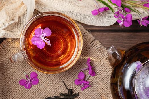 Herbal tea made from fireweed known as blooming sally in teapot and cup, top view.