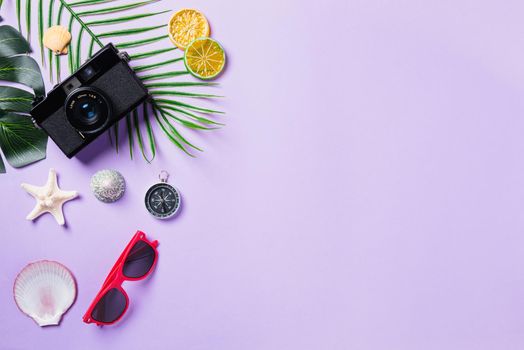 Top view flat lay mockup of camera films, shells, leaves, starfish beach traveler accessories on a purple background with copy space, Business trip, and vacation summer travel concept