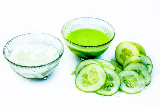 Cucumber face pack isolated on white i.e. Cucumber pulp well mixed with dahi or yogurt in a glass bowl and entire raw ingredients present on the surface.Used to cure acne prone skin.