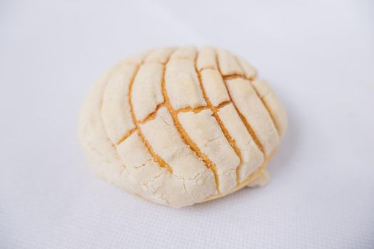 Piece of vanilla sweet bread isolated on white table from above. Top view of classic Mexican bread known as concha on table. Traditional Mexican desserts