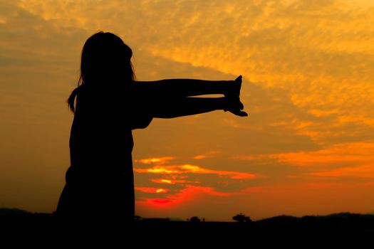 Silhouette of woman exercises at sunset Yellow on sky beautiful in summer