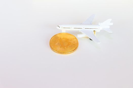 bitcoin coins and model of passenger plane  over white on black background. with copy space add text