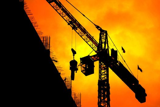 Silhouette Tower crane construction work on sunset time background and copy space add text