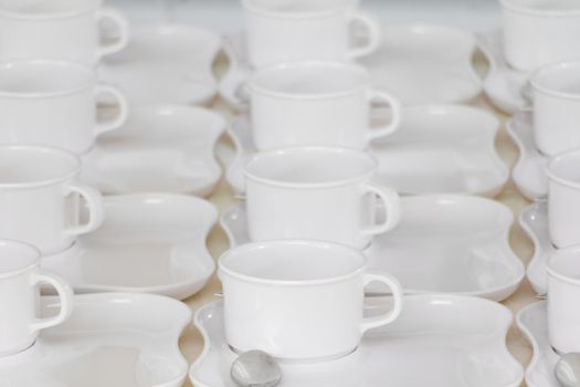 white coffee cup row with saucer and spoon on table