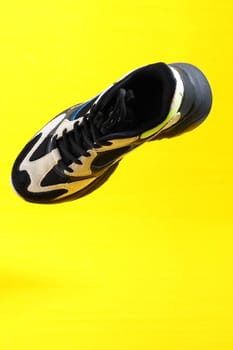 Sneakers on a yellow background. Stylish sports shoes, close-up, isolated, levitation. High quality photo