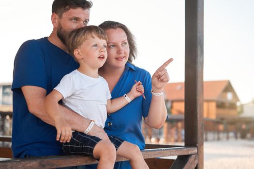 Mother father kid spending time together family vacation Parent dad mom walking with son enjoying sea beach Happy family concept. Blue color clothes. Family with one child