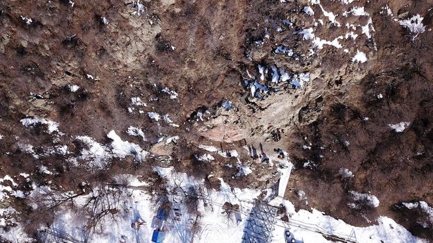 A group of people are engaged in rock climbing. High steep cliff. With the help of a rope, insurance and a partner, climbers climb to the top. Winter time of the year, sometimes there is snow.