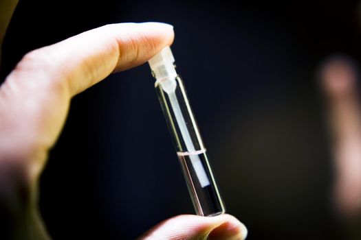 Perfume sample in a small clear glass bottle. Copy space