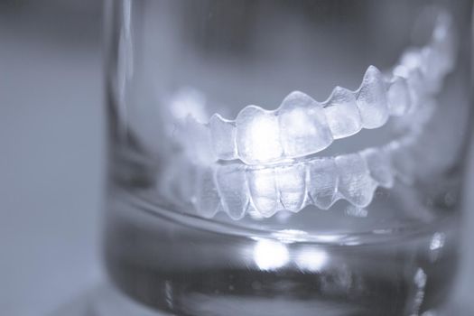 Transparent tooth aligner inside a crystal glass. No people