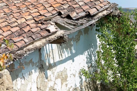 Broken from time to time tiled house. Front view.