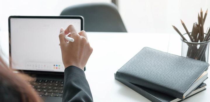 Close up view of female designer hands typing on computer laptop while working at modern startup office..