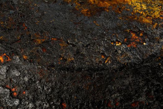 Bottom side of a cast iron pan with thicl layer of soot on its surface. Texture and background.