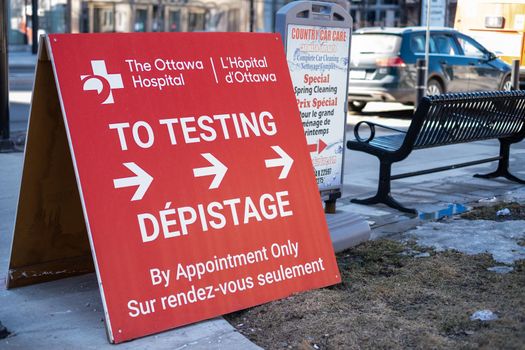 Ottawa, Ontario, Canada - March 20, 2021: Signs outside a downtown COVID-19 drive-through testing centre direct drivers to the testing facility.