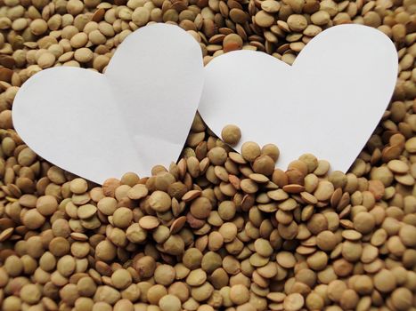 White Heart shape on Heap of raw lentils background