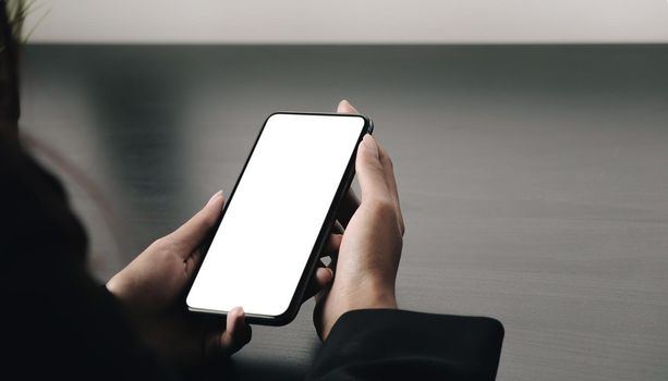 Top view Woman sitting and holding blank screen mock up mobile phone.