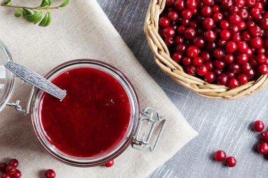 Glass jar with homemade lingonberry sauce. Canning lingonberry sauce, top view, flat lay.