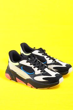 Sports shoes. The sneakers are stylish in isolation on a yellow background. High quality photo