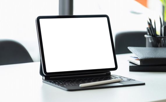 Digital tablet with blank screen on workplace desk.