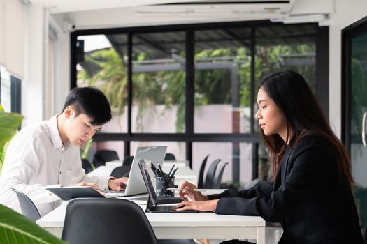 Group of young asian business people working with laptop computer at modern office.