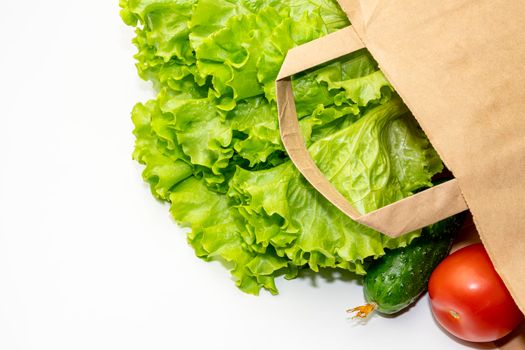 paper bag with cucumbers tomatoes and lettuce. High quality photo