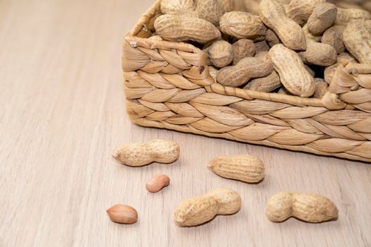 peanuts unpeeled in a basket on a wooden background. High quality photo