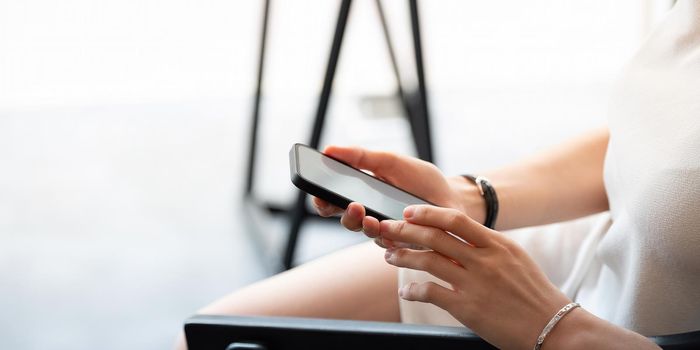 Close up business woman using smart phone at cafe.