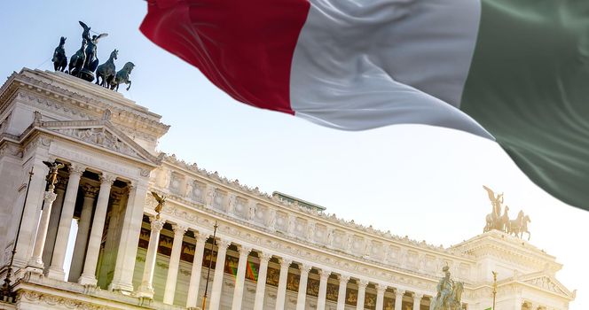 The Italian flag waving in the wind with Vittoriano in Rome in the background. Travel and tourist destinations. Art and architecture. World famous Italian historical monument