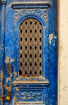 Old blue wooden door in Lisbon. Wrought metal details on the door.