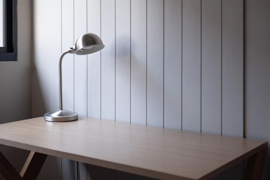 Workplace with space - Lamp on old wood table with space of rough cement wall in white color tone.