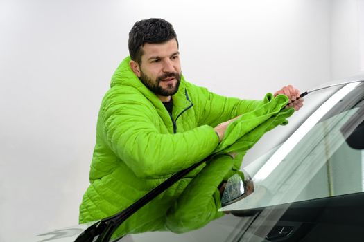 man cleans the car body with a towel. auto care.