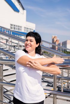 Sport and fitness. Senior sport. Active seniors. Smiling senior woman doing stretching outdoors on urban background