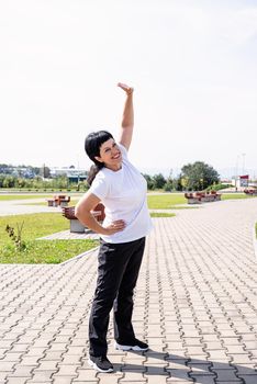 Sport and fitness. Senior sport. Active seniors. Smiling senior woman warming up stretching outdoors in the park