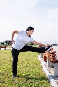 Sport and fitness. Senior sport. Active seniors. Smiling senior woman warming up stretching outdoors in the park