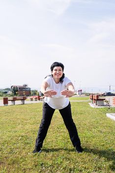 Sport and fitness. Senior sport. Active seniors. Smiling senior woman warming up stretching outdoors in the park