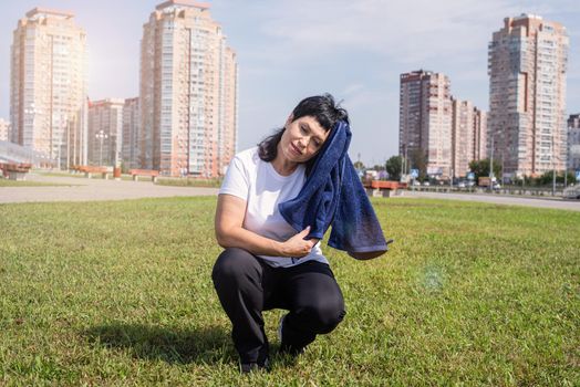 Sport and fitness. Senior sport. Active seniors. senior woman wiping out sweat after hard workout outdoors in the park