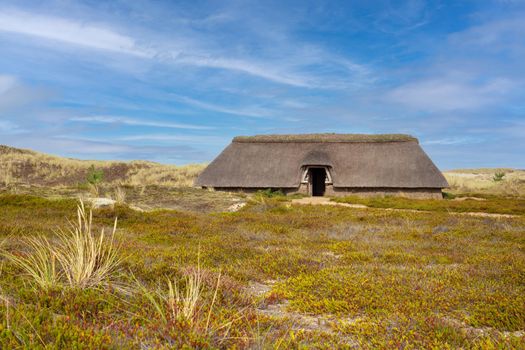 Panoramic image of a traditional house within the dunes of Amrum against blue sky, North Sea, Germany