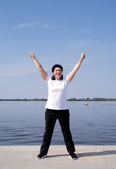 Sport and fitness. Senior sport. Active seniors. Active and happy senior woman exercising near the riverside