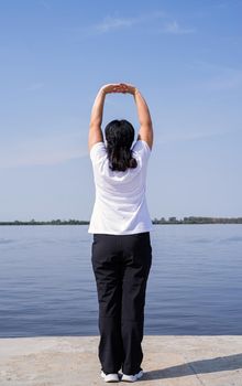 Sport and fitness. Senior sport. Active seniors. Active and happy senior woman exercising near the riverside