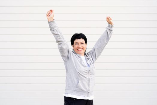 Sport and fitness. Senior sport. Active seniors. Senior woman stretching her legs outdoors on the sports ground